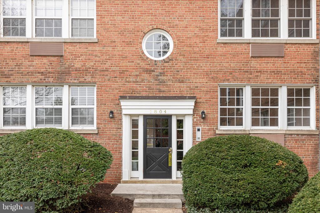 Red-brick building entrance with a black door marked 804 and a round window above.