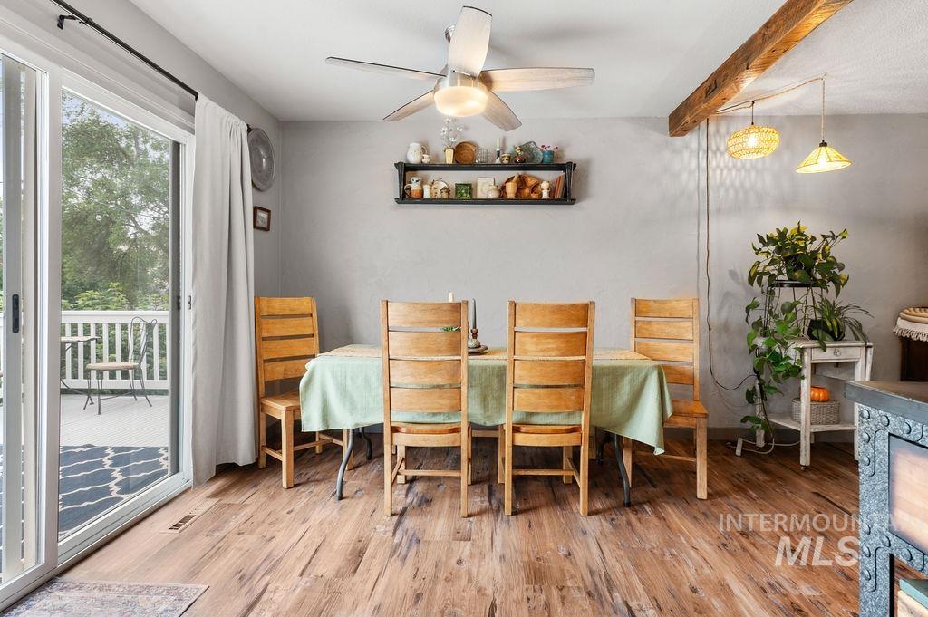 Dining room with wooden chairs, a green tablecloth, and sliding glass doors opening to a deck.