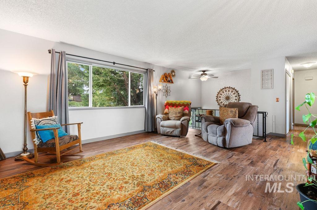 Furnished living room with two recliners, a rocking chair, and a large patterned rug.