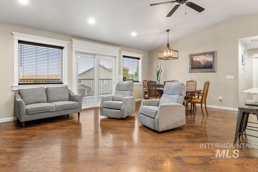 Living room with gray seating, hardwood floors, and an adjoining dining area.
