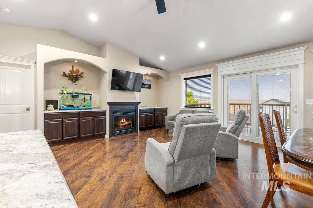 Living room with gray recliners, a fireplace, dark wood floors, and a sliding door to the balcony.