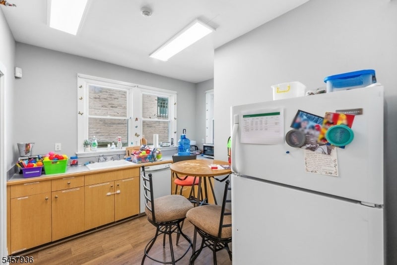 Kitchen with wood cabinets, a double window over the sink, and a white refrigerator.