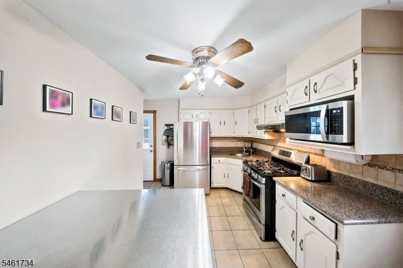 Kitchen with white cabinets, granite countertops, and stainless steel appliances.