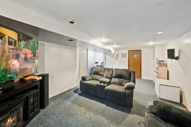 Furnished basement family room with a gray reclining sectional and television.
