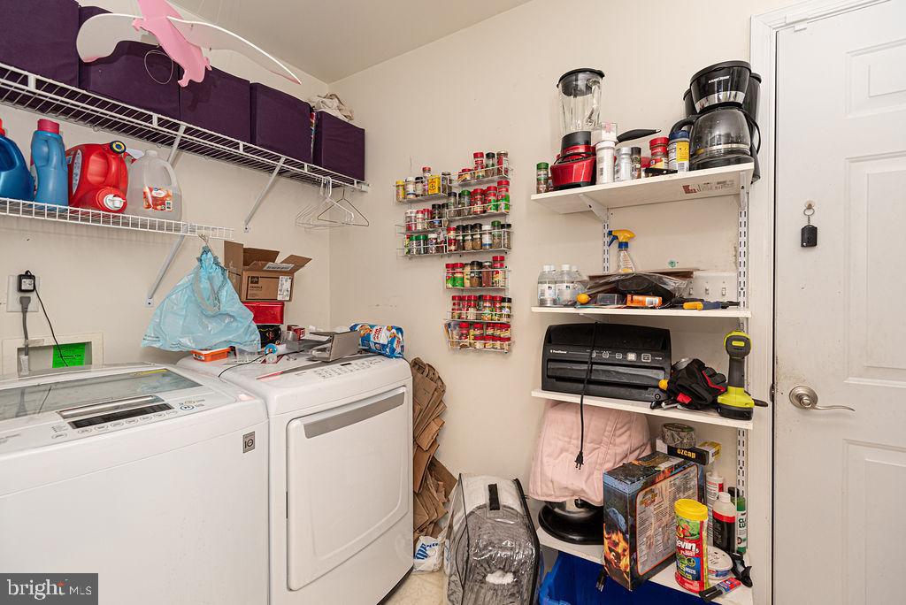 Laundry room with washer and dryer, wire shelving, and storage supplies.