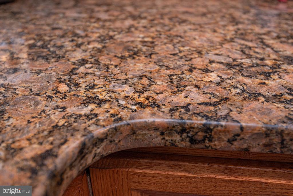 Granite kitchen countertop with a rounded edge above wood cabinetry.