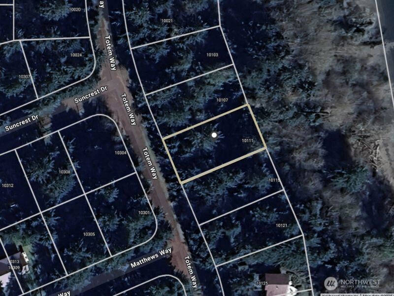 Aerial view of wooded 10111 Totem Way lot outlined beside Totem Way.