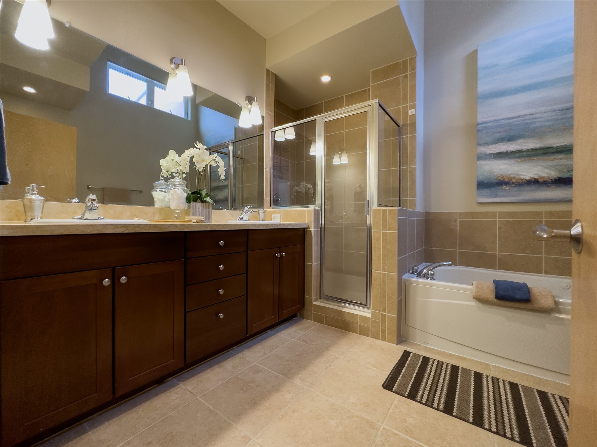 Bathroom with a dark wood vanity, glass shower, and built-in bathtub.