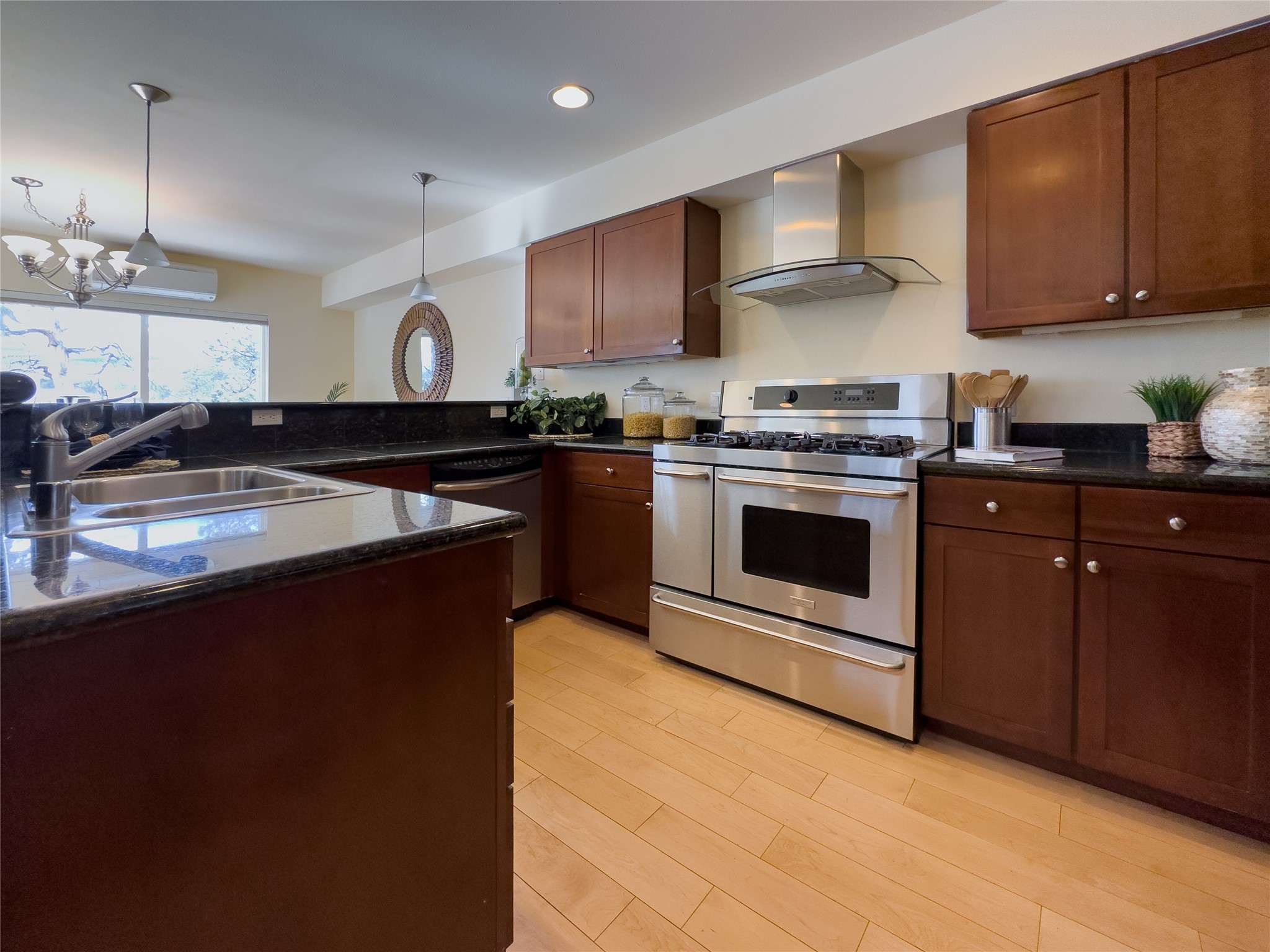 Kitchen with cherry cabinets, black granite counters, and a stainless steel gas range.