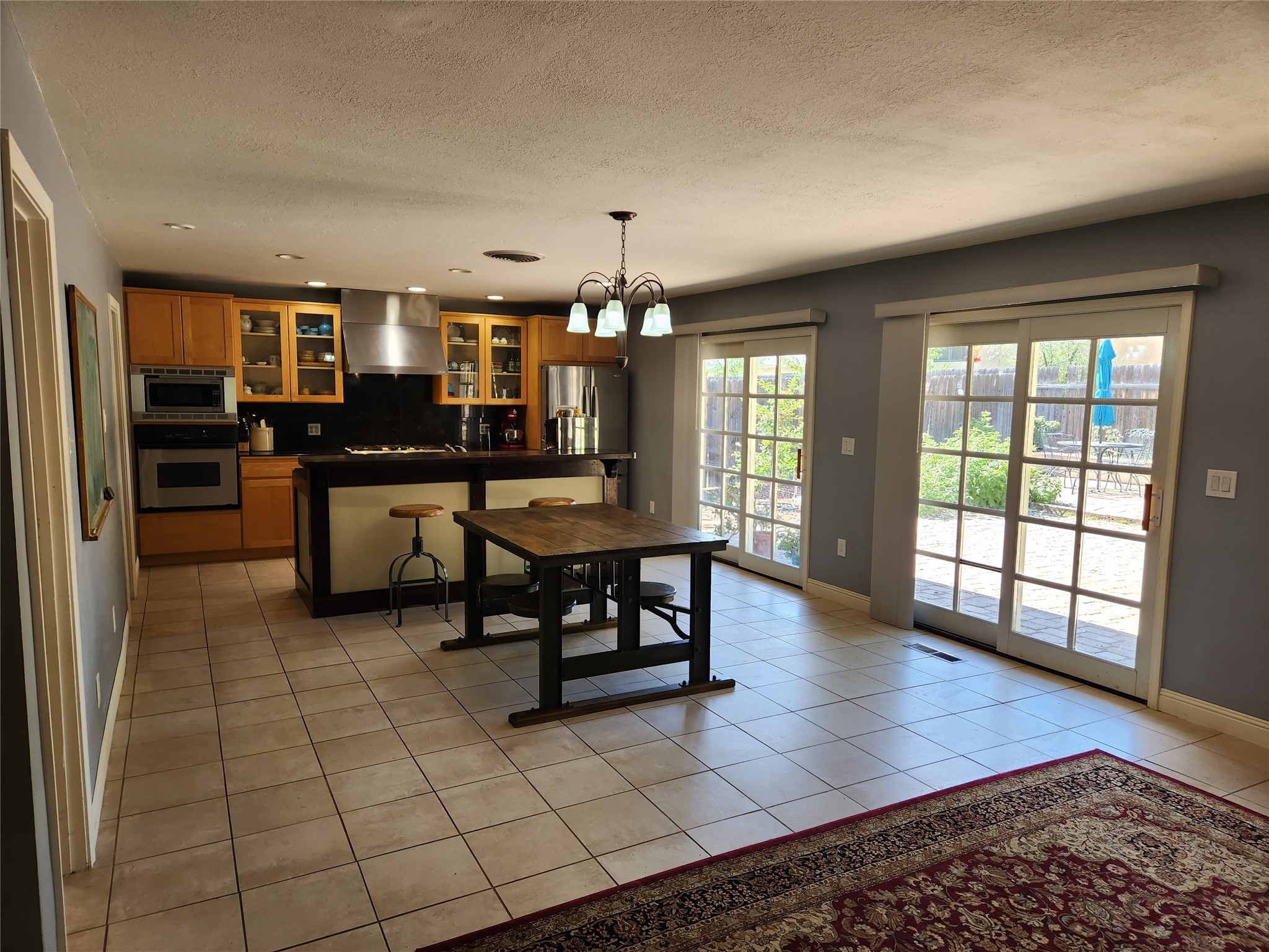 Kitchen and dining area with wood cabinets, a breakfast bar, and French doors to a patio.