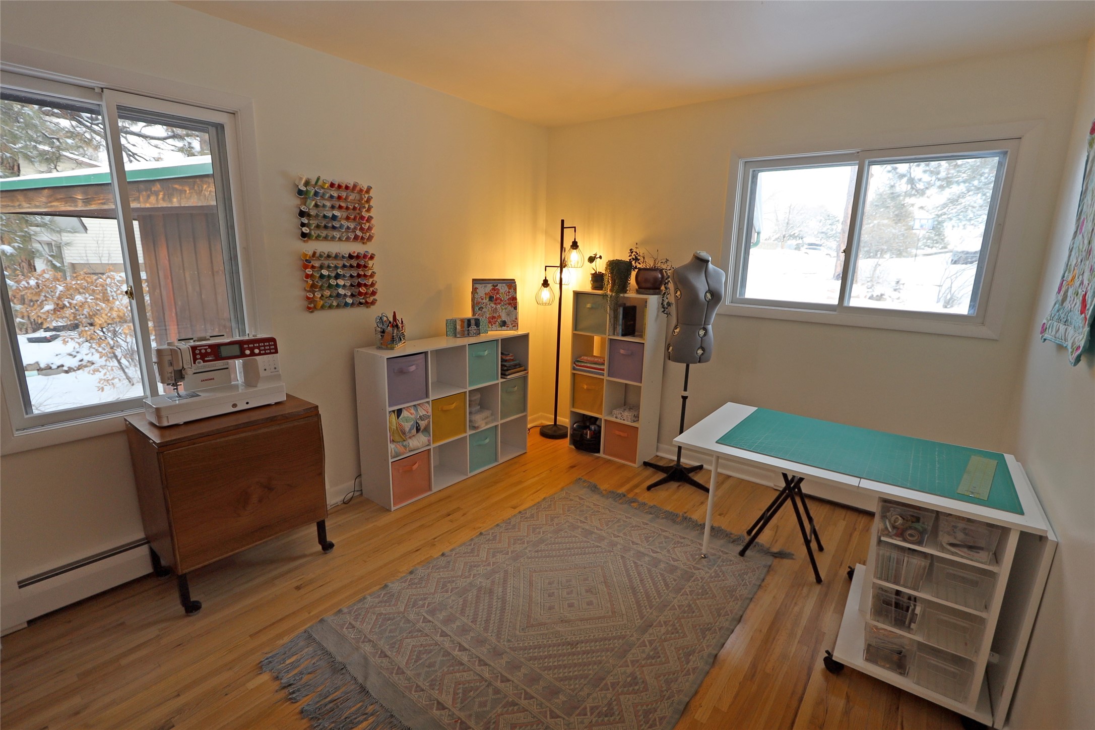 Craft room with sewing machine, dress form, colorful storage, and a large cutting table