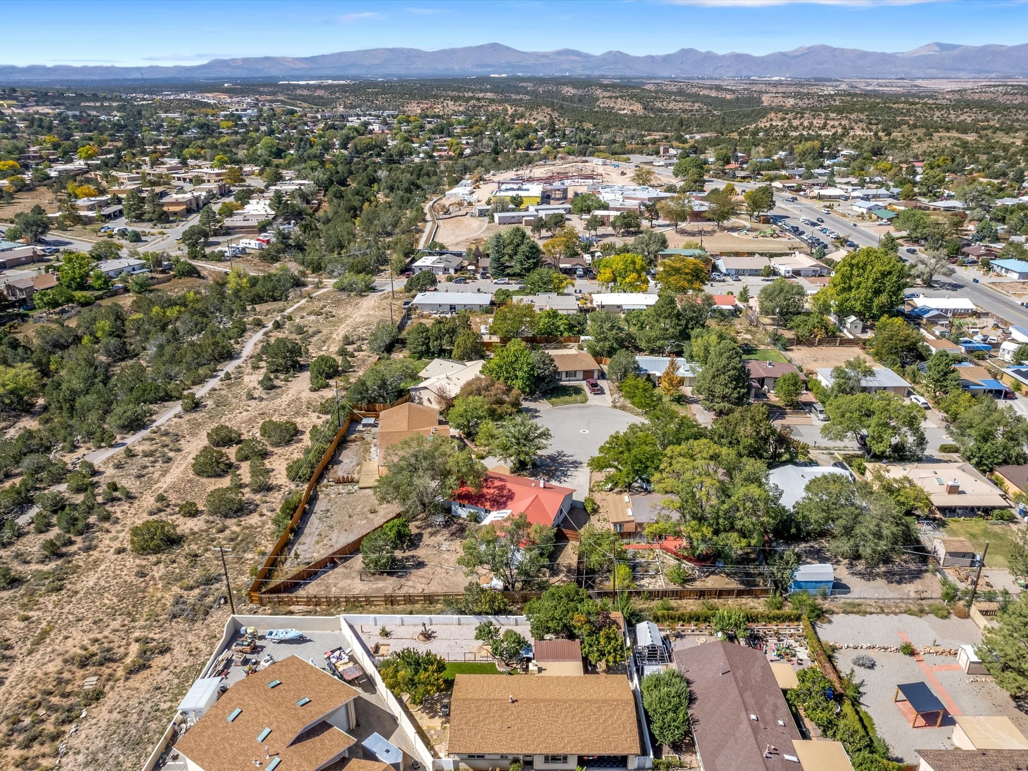 Aerial view of homes and open scrubland in White Rock, with mountains on the horizon.