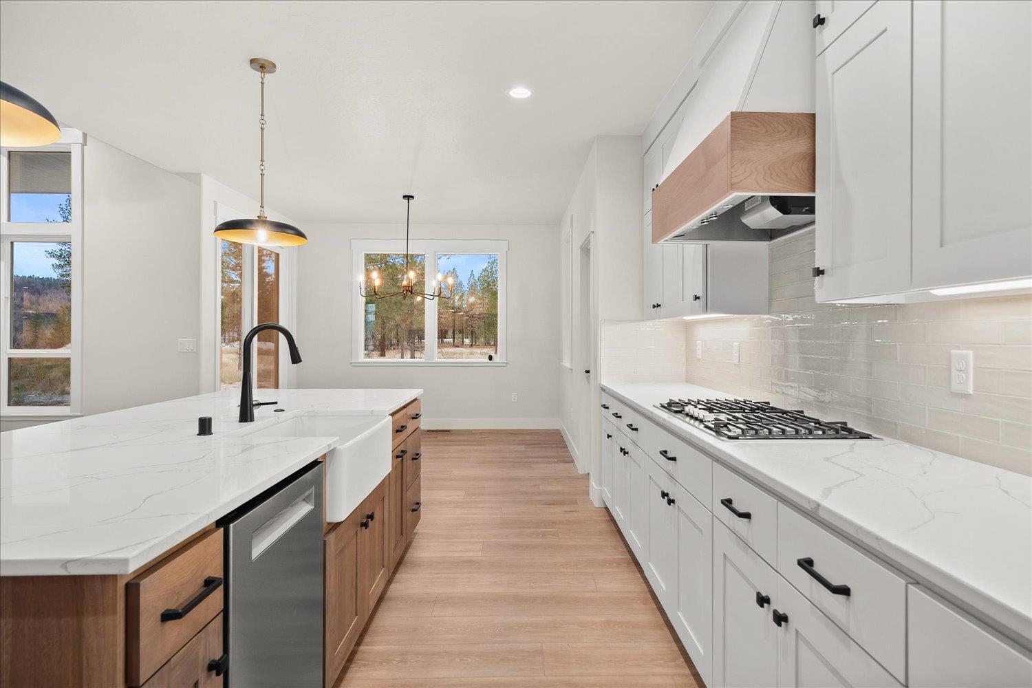 Modern kitchen with white cabinetry, a wood-accented island, and a farmhouse sink.