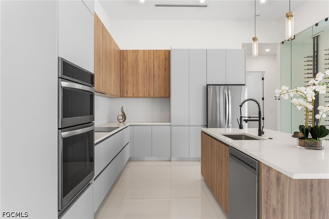 Modern kitchen with wood-accented cabinetry, stainless steel appliances, and a white island.