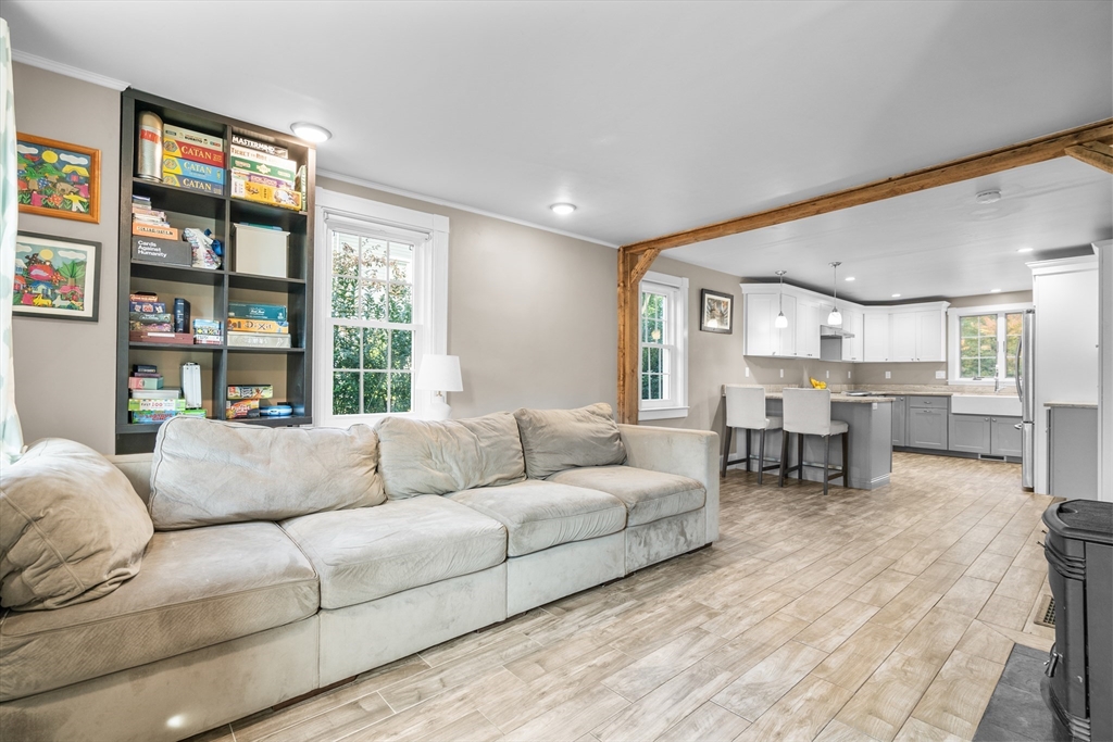 Open living room and kitchen with a large sectional, built-in shelves, and a breakfast bar.