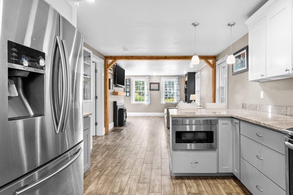 Kitchen with stainless steel appliances and a timber-trimmed opening to the living area.
