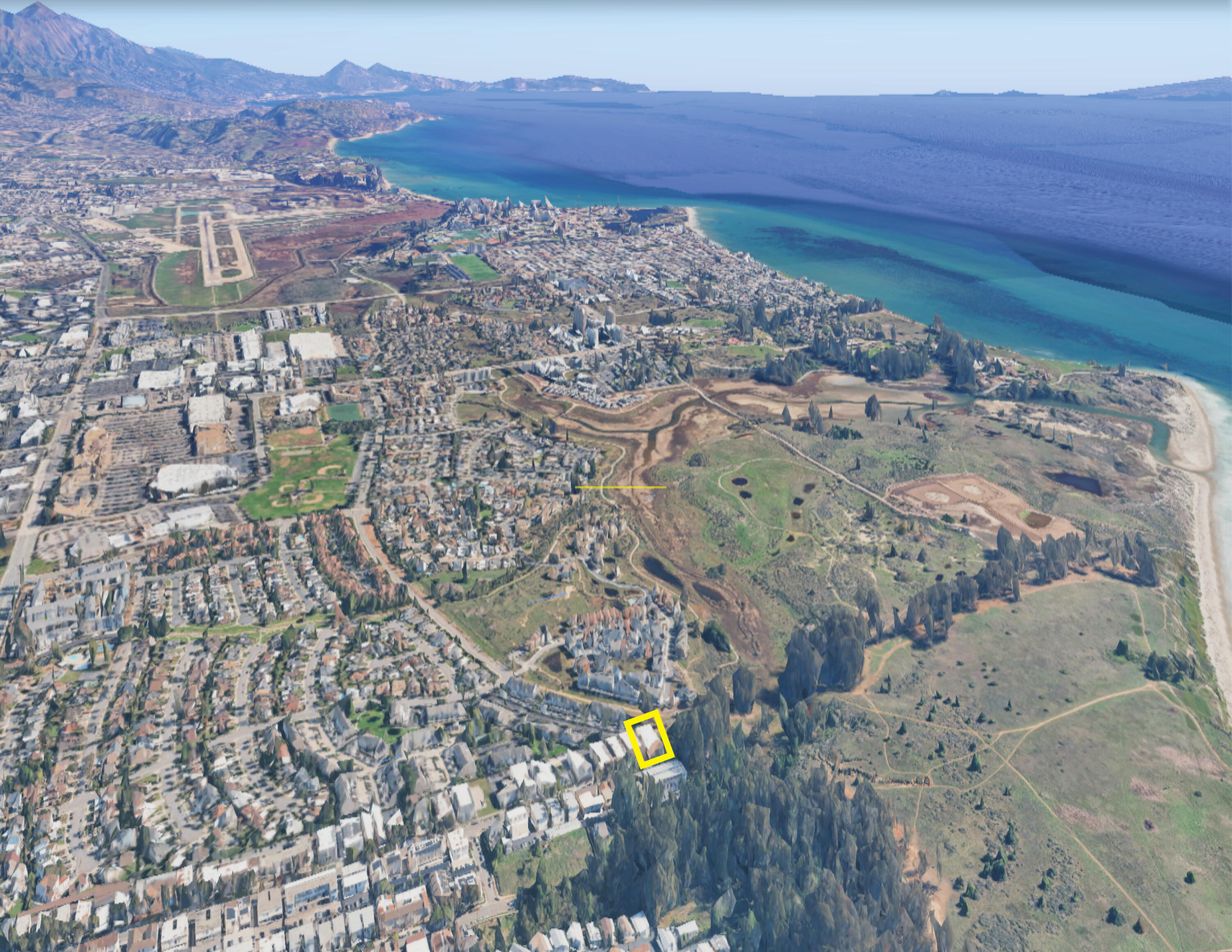 Aerial coastal view with the property outlined in yellow, near the shoreline and open land.