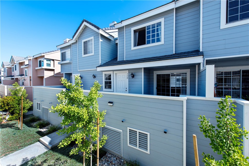 Blue-gray townhouse exterior with a fenced patio and neighboring attached homes.
