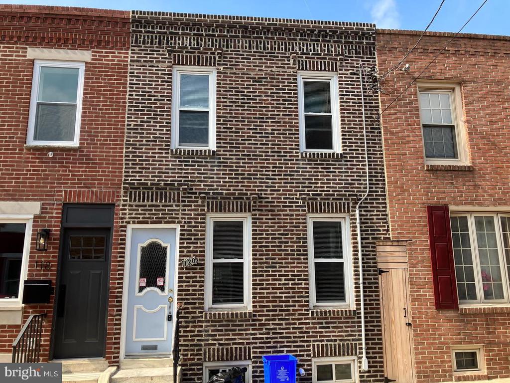 Brick rowhouse with a pale blue front door and white-trimmed windows.