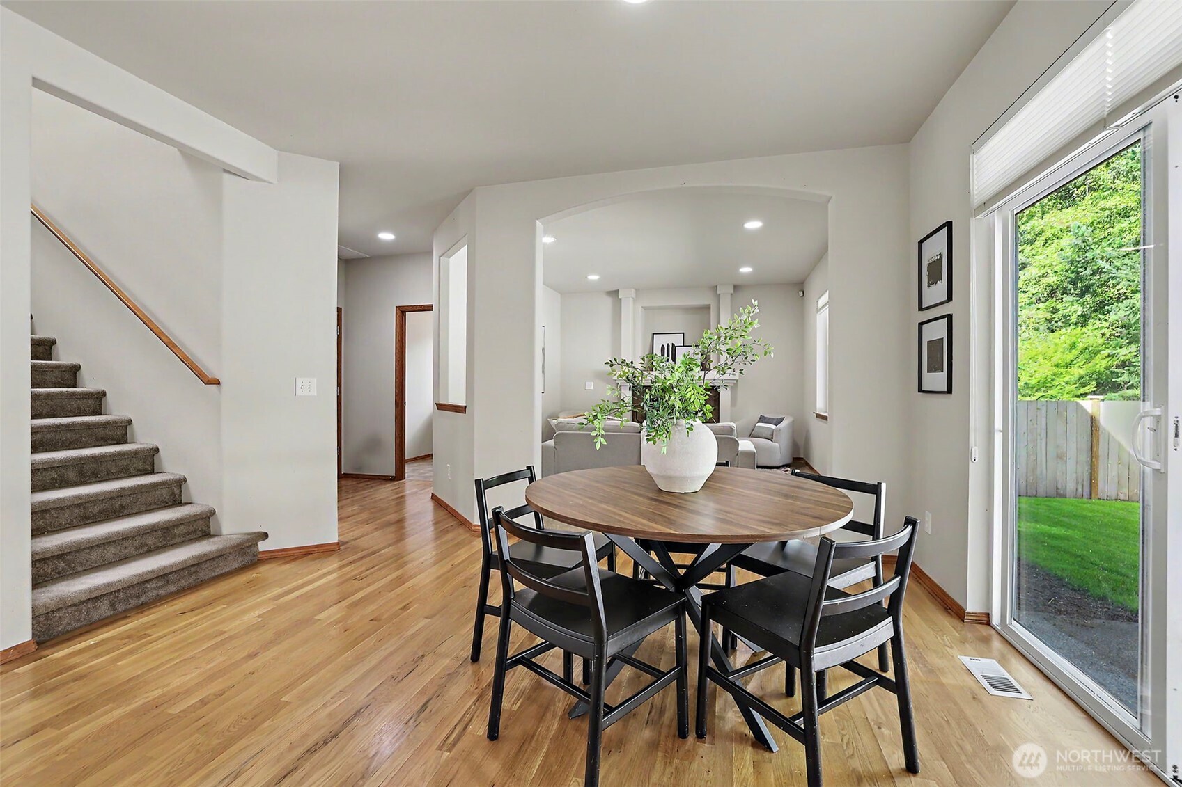 Dining area with a round table beside sliding glass doors, opening toward the living room.