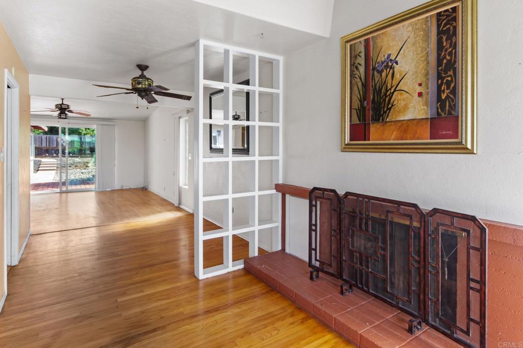 Living room with hardwood floors, a tiled fireplace, and sliding doors to a patio.