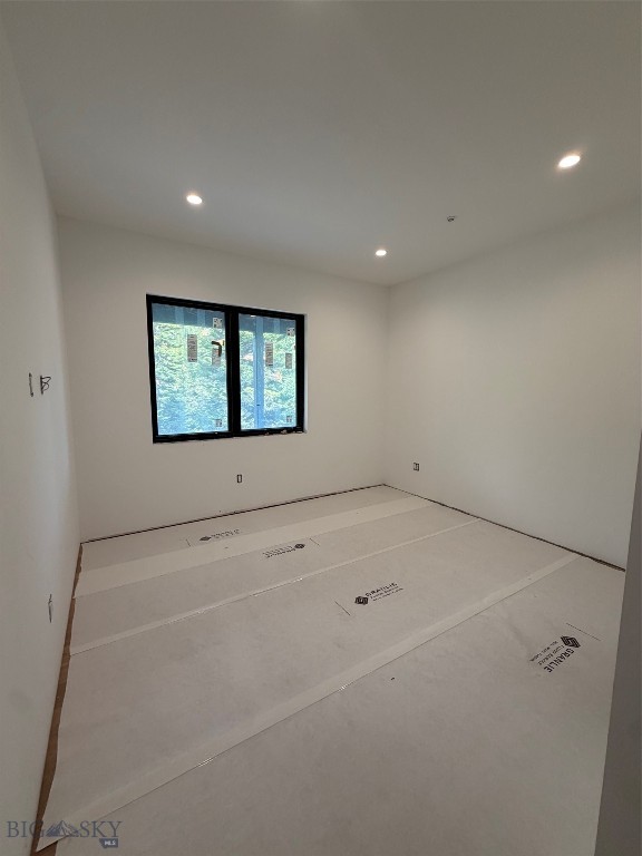 Unfinished room with a black-framed window and protective floor covering.