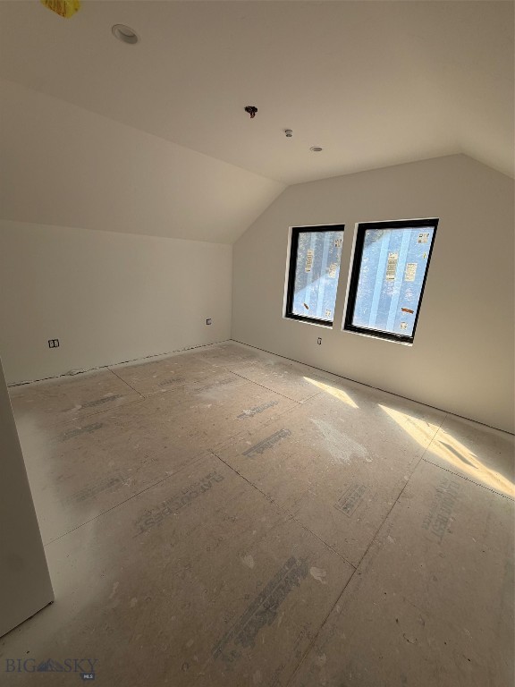 Unfinished room with two windows, bare subfloor, and recessed ceiling lights.