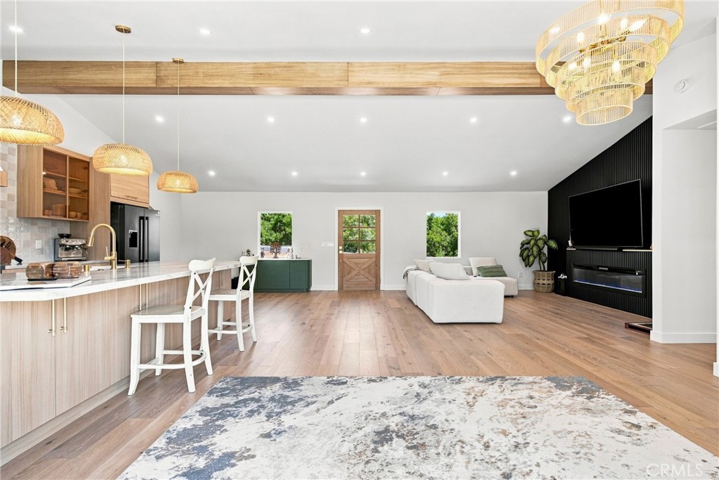 Open-plan kitchen and living room with a large island, white sectional, and black accent wall.