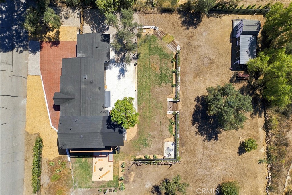 Aerial view of the home and large lot, with a fenced yard and detached structure.