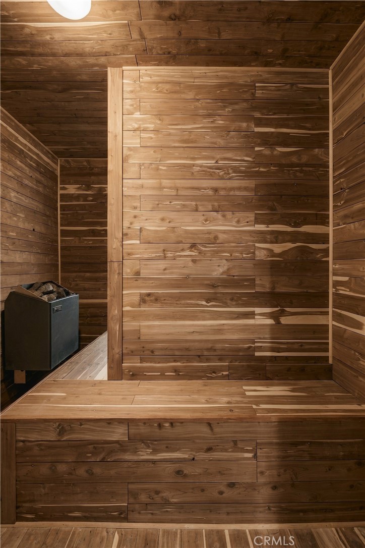 Wood-paneled sauna with a built-in bench and stone-filled heater.