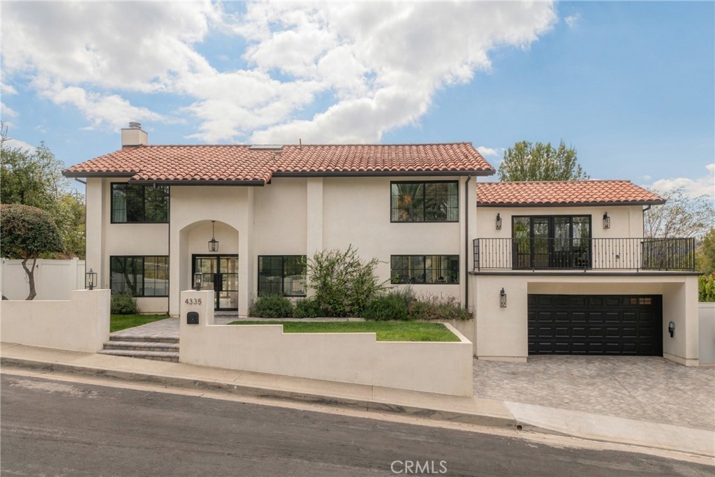 Two-story stucco home with a terracotta tile roof, balcony, and attached garage.