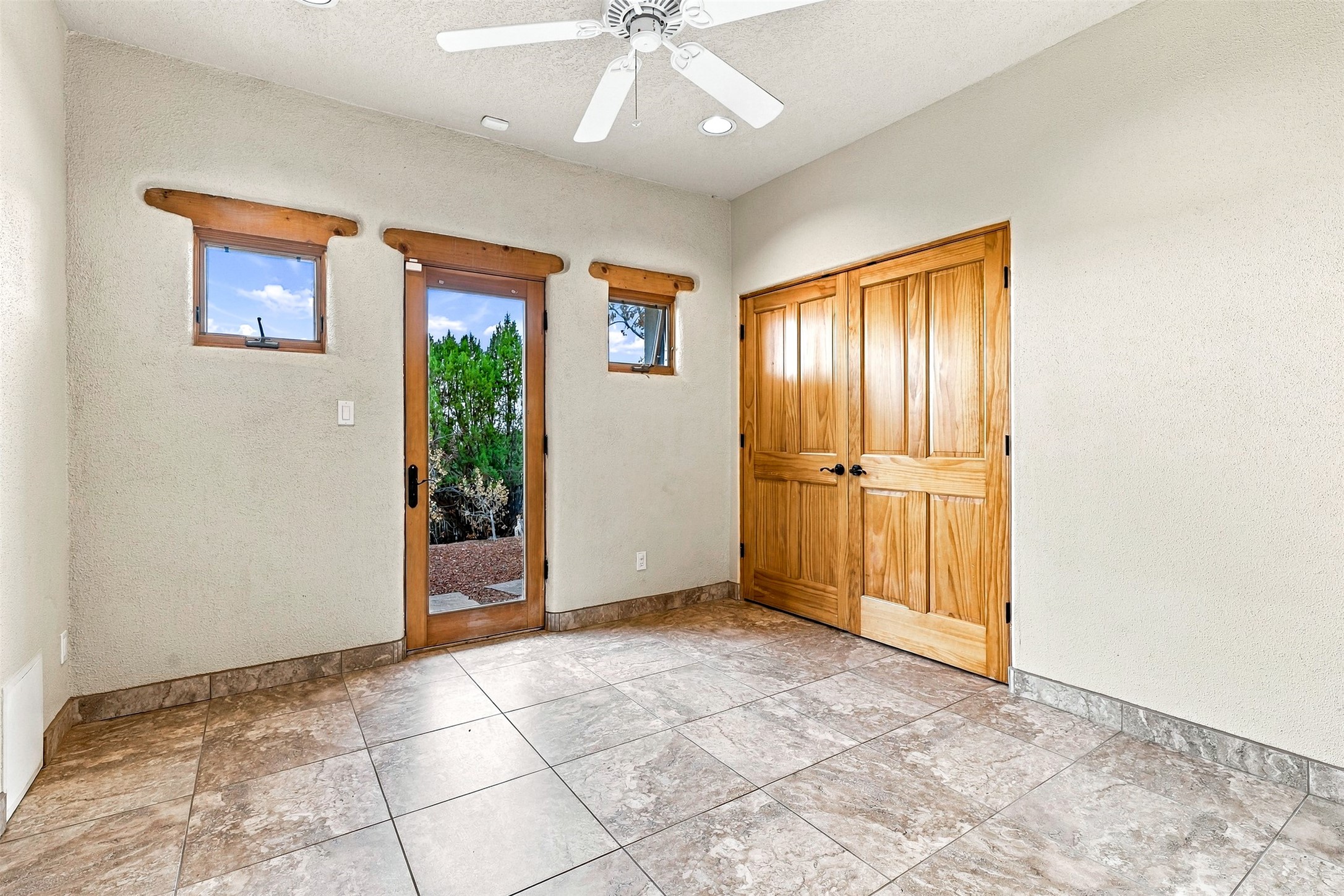 Tiled entry room with a glass exterior door and wood double closet doors.