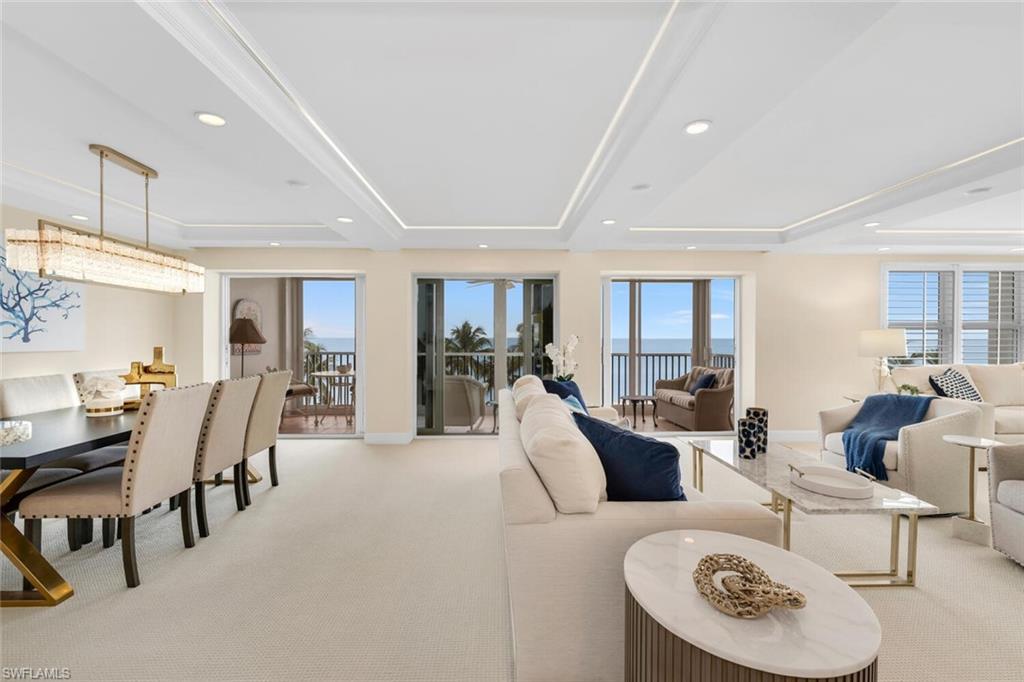 Furnished living and dining room with sliding glass doors overlooking the ocean.