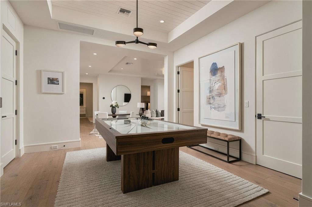 Game room with a dark wood pool table, pale rug, and vaulted paneled ceiling.