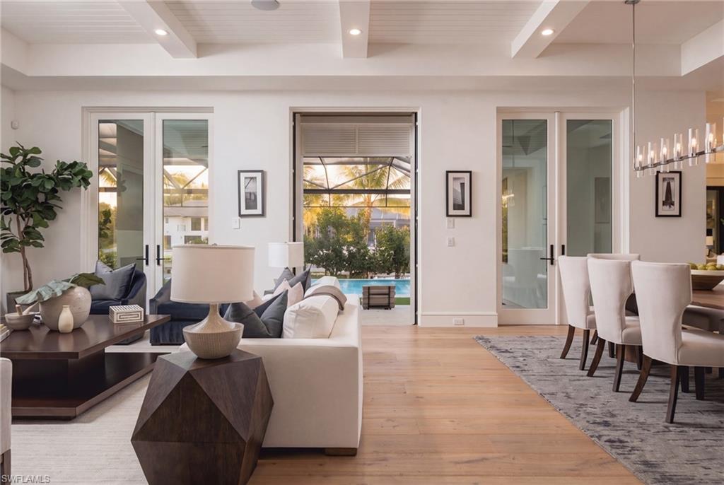 Open living and dining room with glass doors overlooking a screened pool area.