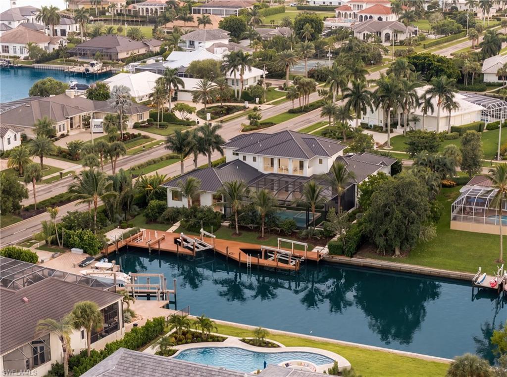 Canal-front home with a private dock and screened pool, surrounded by waterfront houses.