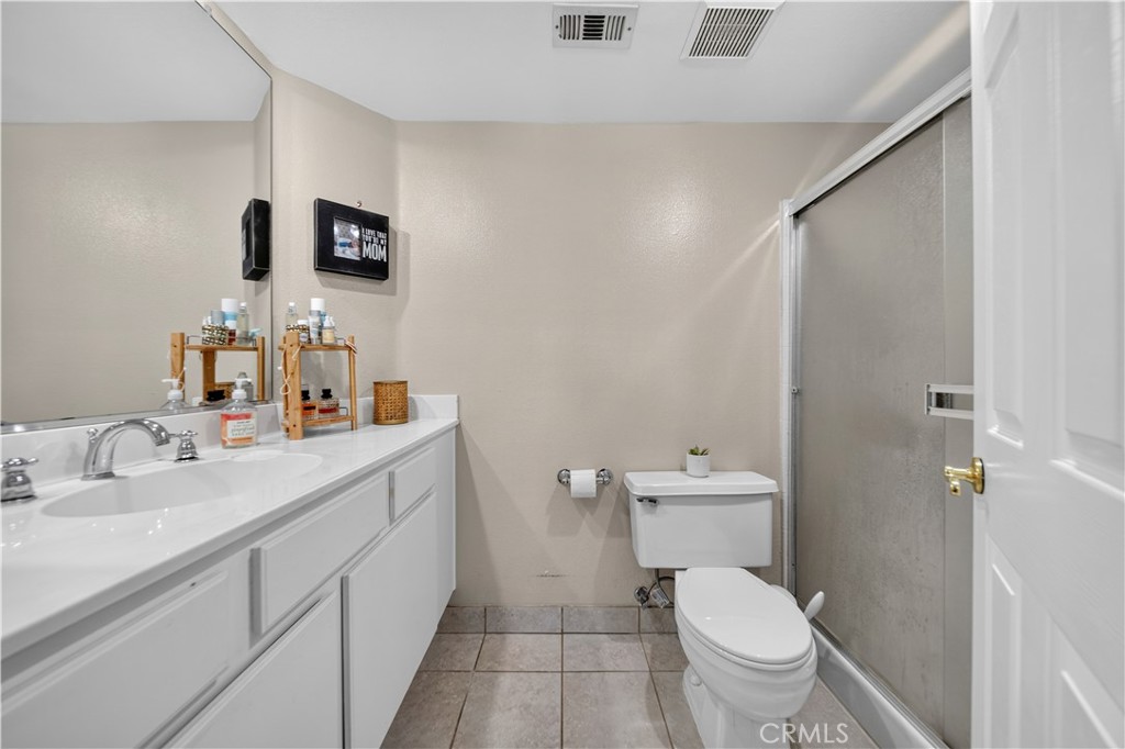 Bathroom with a white vanity, toilet, and glass-enclosed shower.