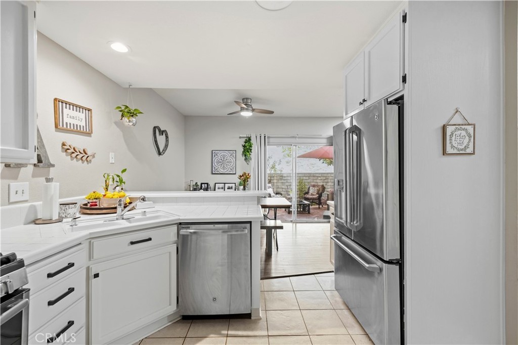 Kitchen with white cabinetry, stainless steel appliances, and sliding doors opening to a patio.
