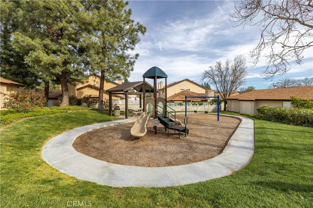 Community playground with slides and swings inside a circular paved path.