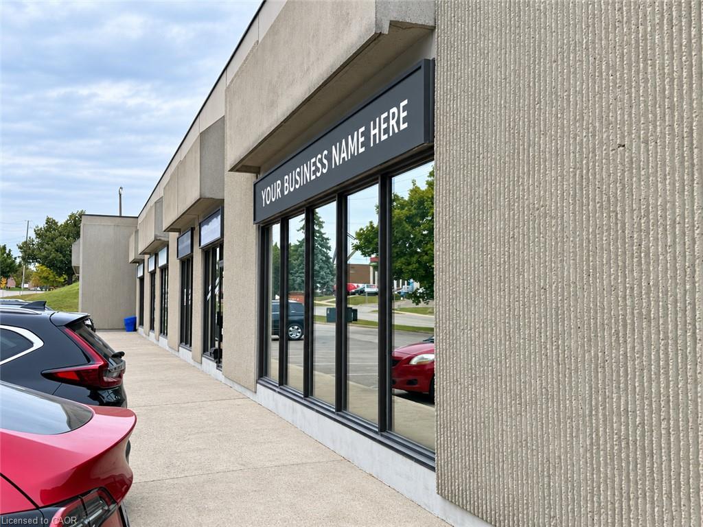 Commercial storefront with large glass windows and a placeholder business sign.
