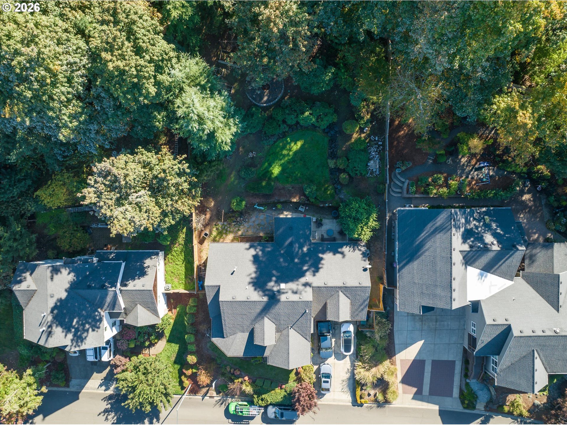 Aerial view of a home with a leafy, landscaped backyard and patio.
