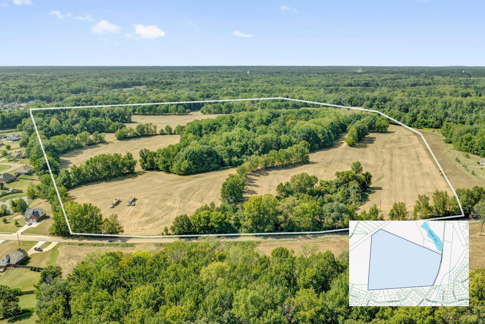 Aerial view of a large parcel with open fields and wooded areas, outlined in white.