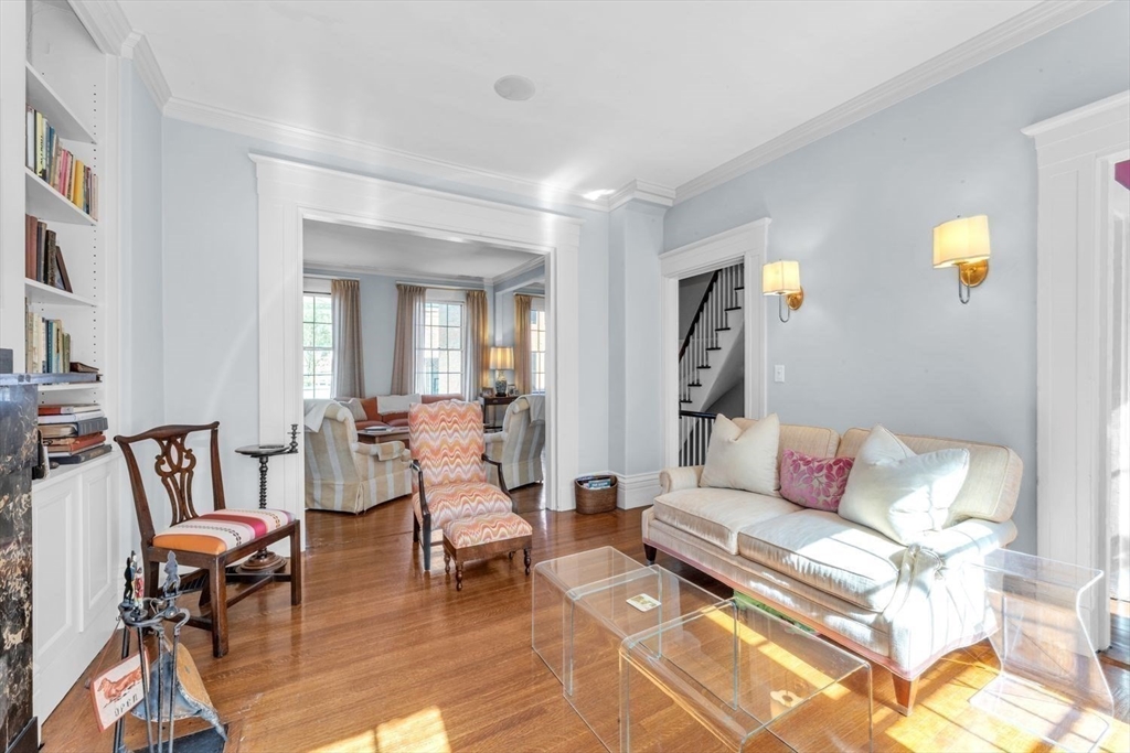 Living room with pale blue walls, hardwood floors, built-in bookshelves and a cream sofa.