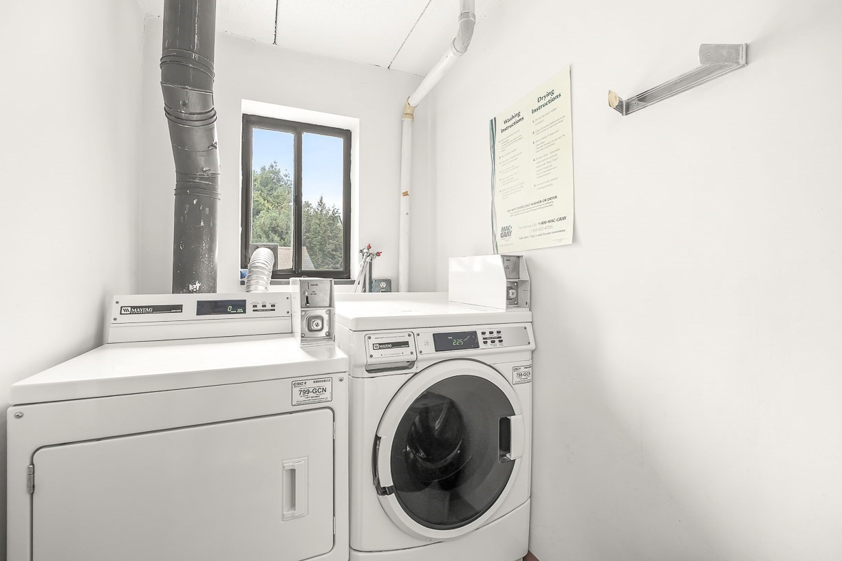 Laundry room with Maytag washer and dryer, a window, and exposed ductwork.
