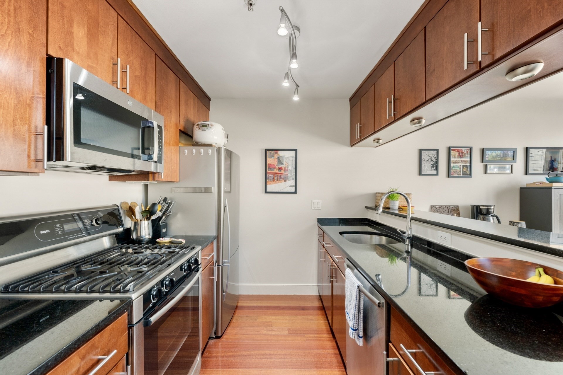 Kitchen with cherry cabinets, black granite counters, stainless steel appliances, and a long peninsula.