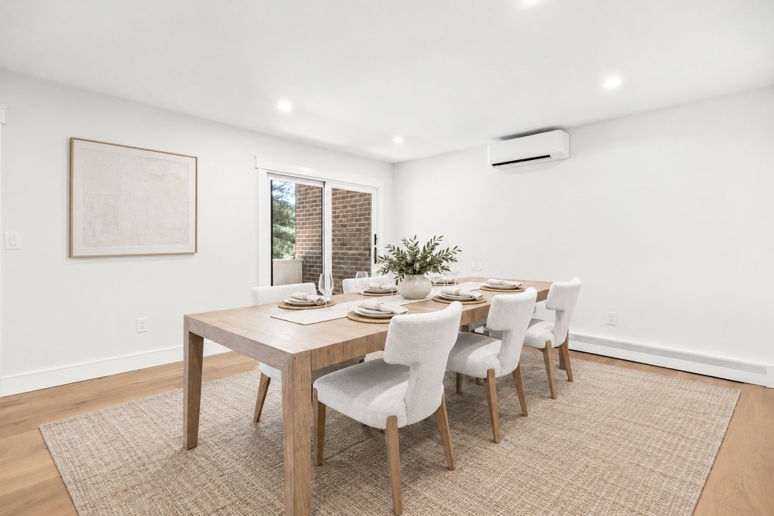 Staged dining room with a set table, upholstered chairs, and sliding glass door.