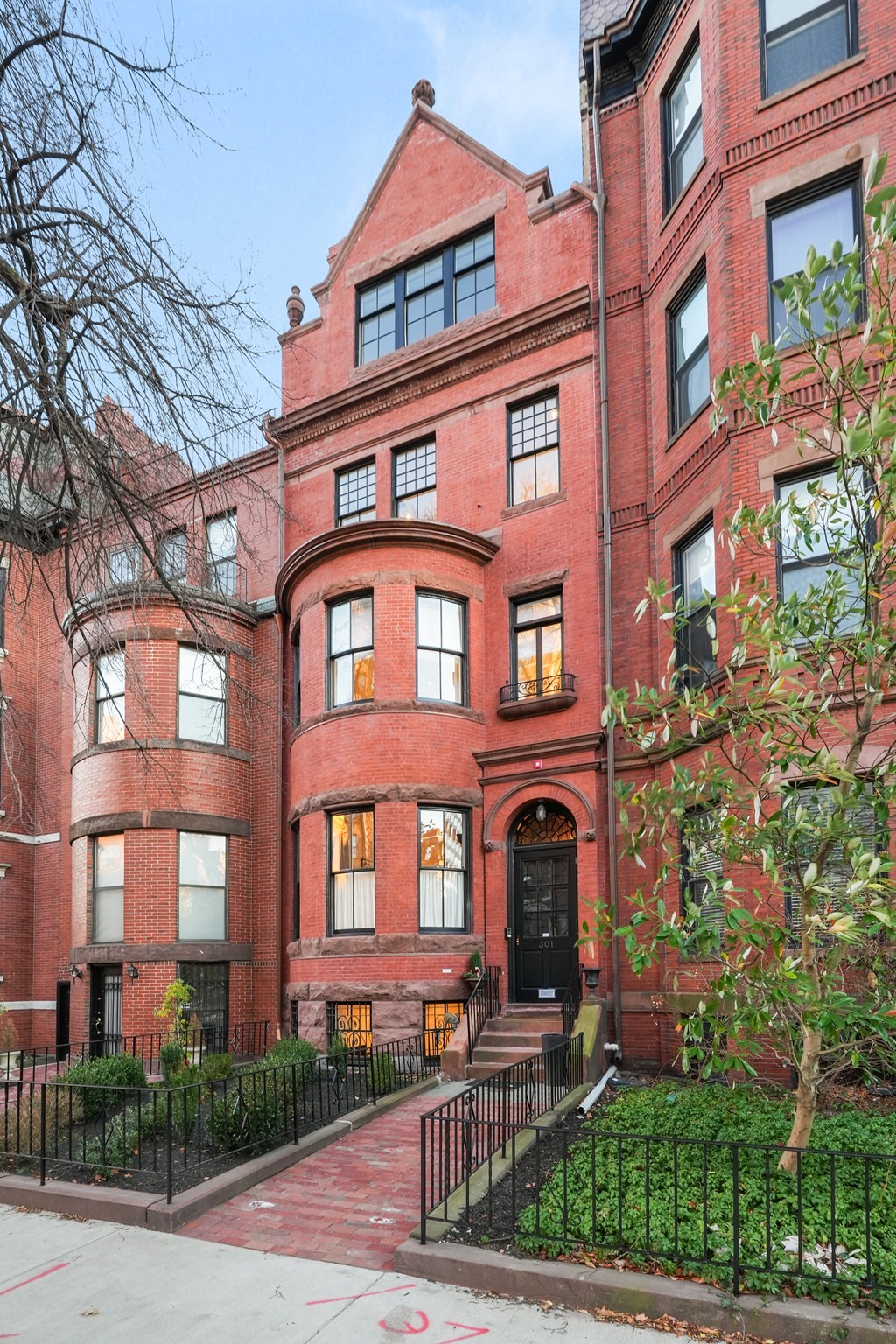 Red-brick building with bay windows and an arched entrance marked 301.