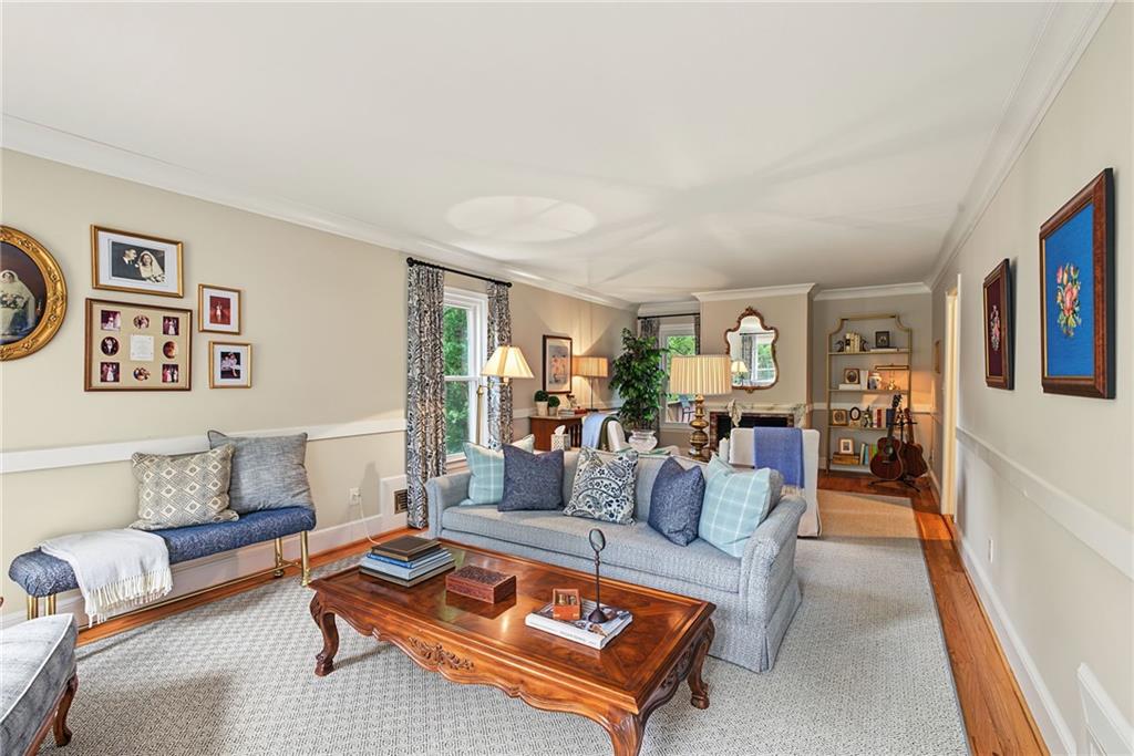 Furnished living room with a blue-gray sofa, carved wooden coffee table, and framed wall art.