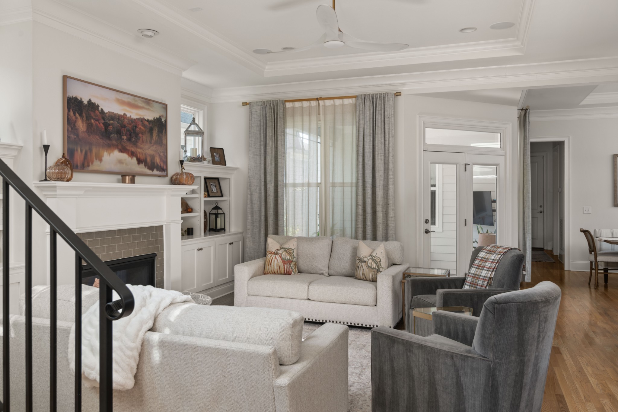 Staged living room with a fireplace, built-in shelving, and seating around a light rug.