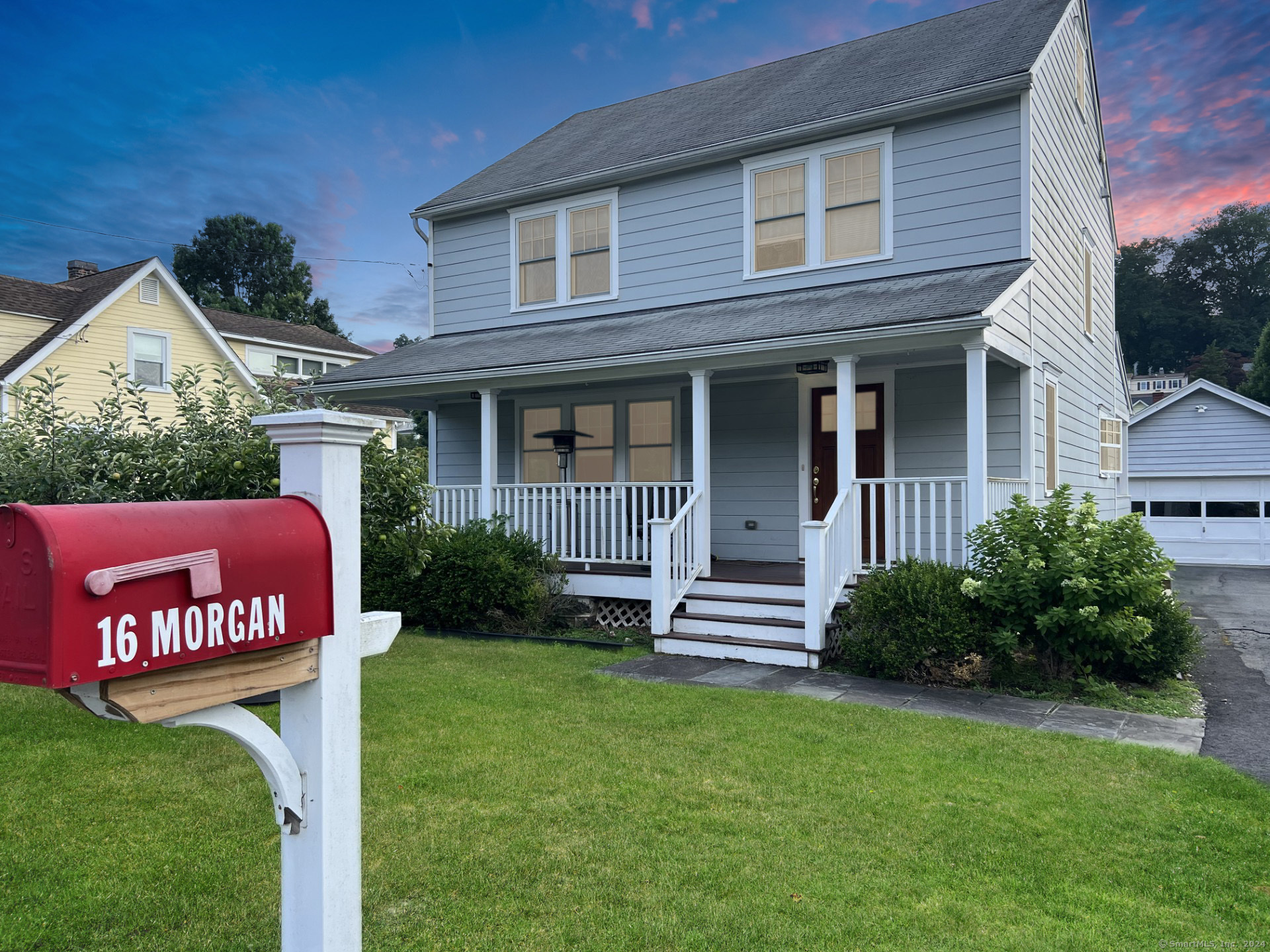 Two-story blue house with a white-columned porch and red mailbox marked 16 Morgan.